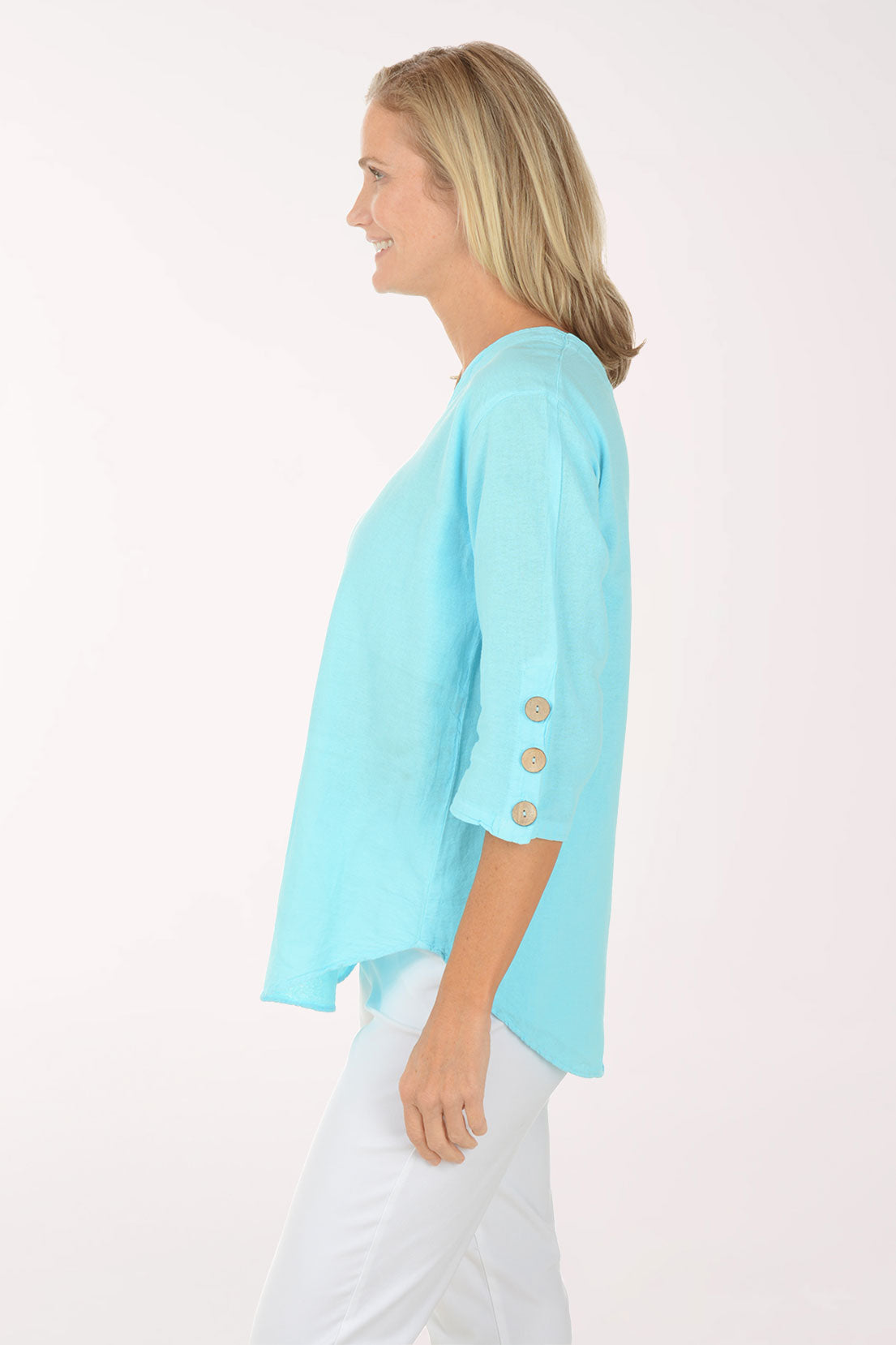 Woman wearing a light blue top with button details on a white background