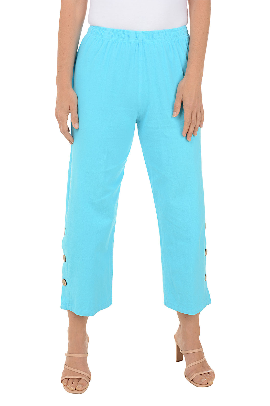 A front shot of a model wearing a pair of Turquoise capri pants with side button detail on the hemline, made of crinkle cotton fabric.