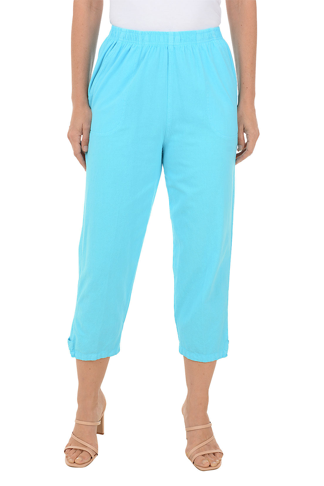 A front shot of a model wearing a pair of turquoise capri pants with button-tab detail on the hemline, made of crinkle cotton fabric, with an elastic waistband and side pockets.