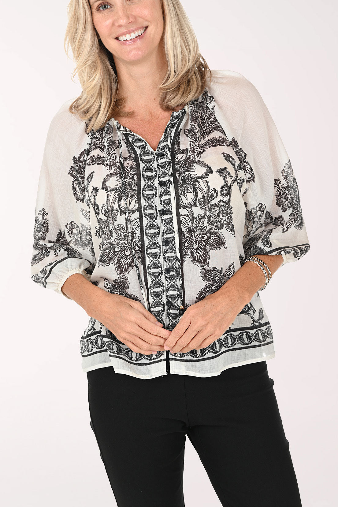 Woman wearing a patterned blouse with a white background