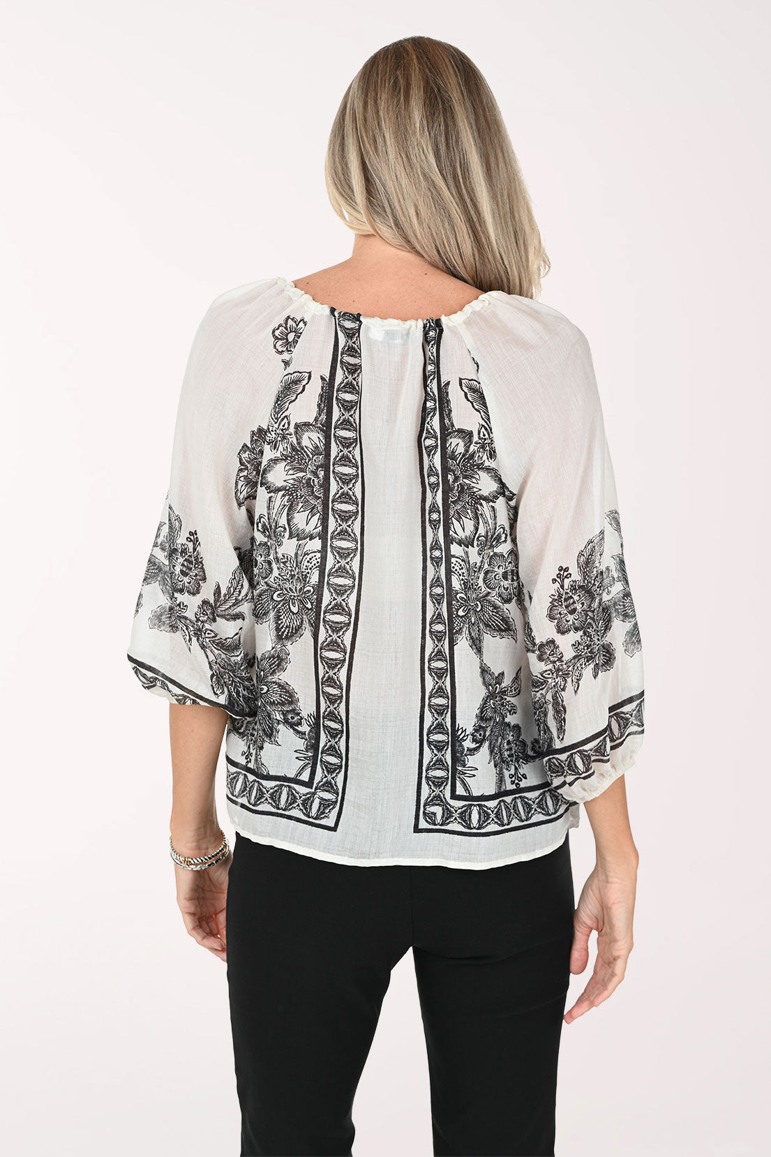 Woman wearing a patterned blouse with a white background
