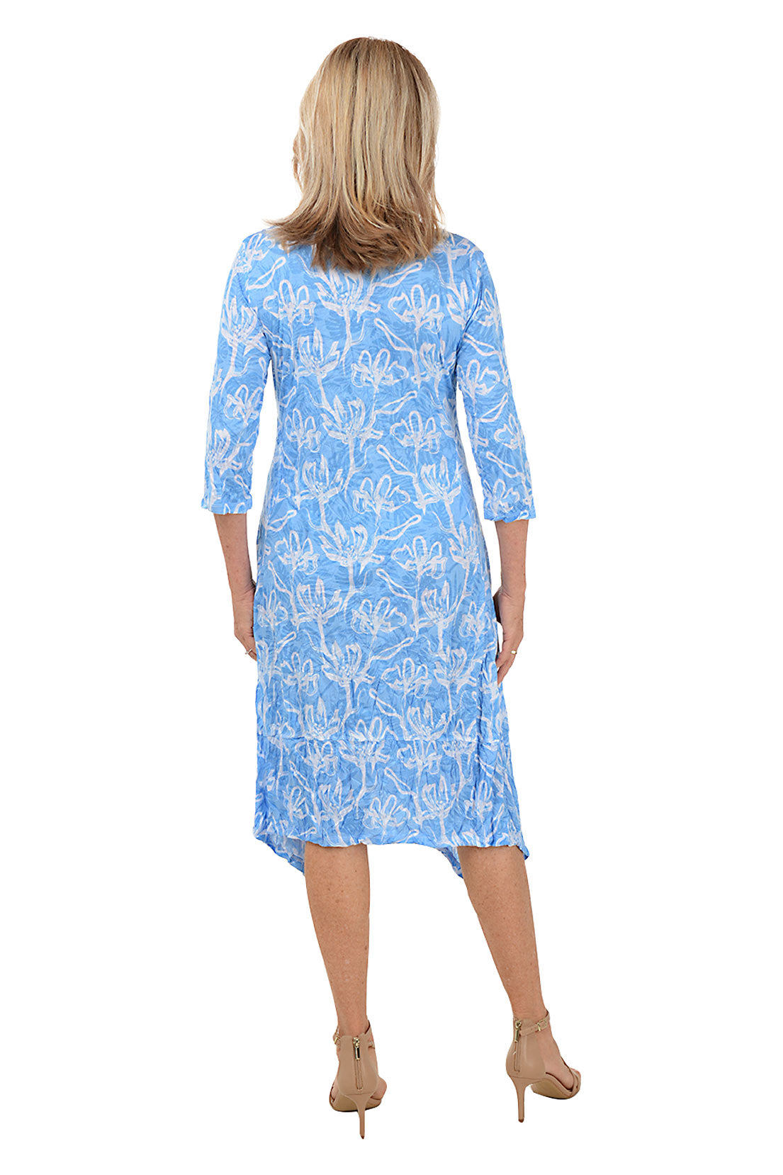A back shot of a model wearing a blue and white floral 3/4 sleeve knee-length dress with a scoop neckline and a shark bite hemline.