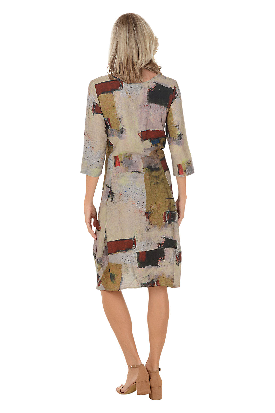 A woman wearing a 3/4 sleeve brown dress with a red and green multi colored pattern. Back shot.