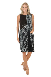 Woman wearing a black and white sleeveless dress with a left hip pocket.