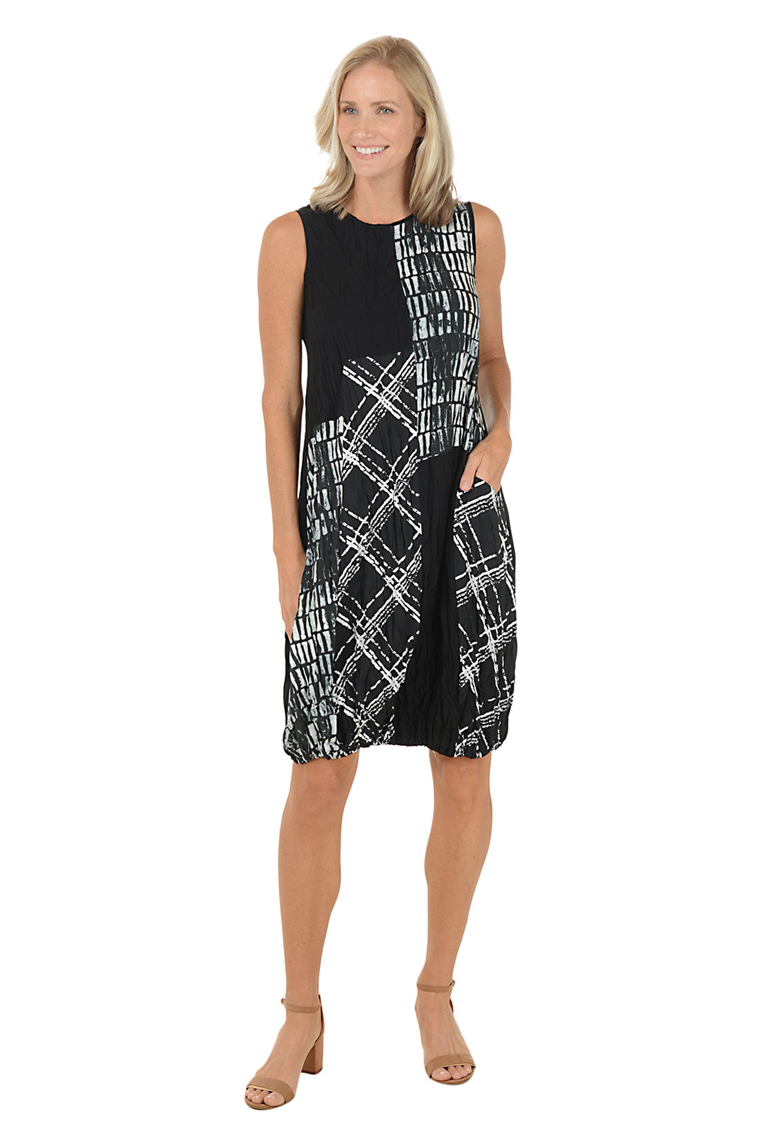 Woman wearing a black and white sleeveless dress with a left hip pocket. Second front shot.