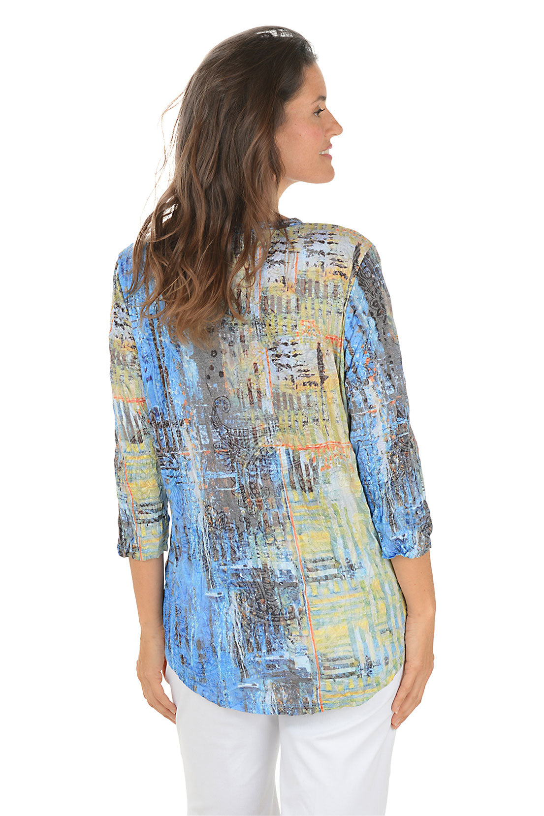 Woman wearing a colorful abstract patterned top on a white background. Back shot.