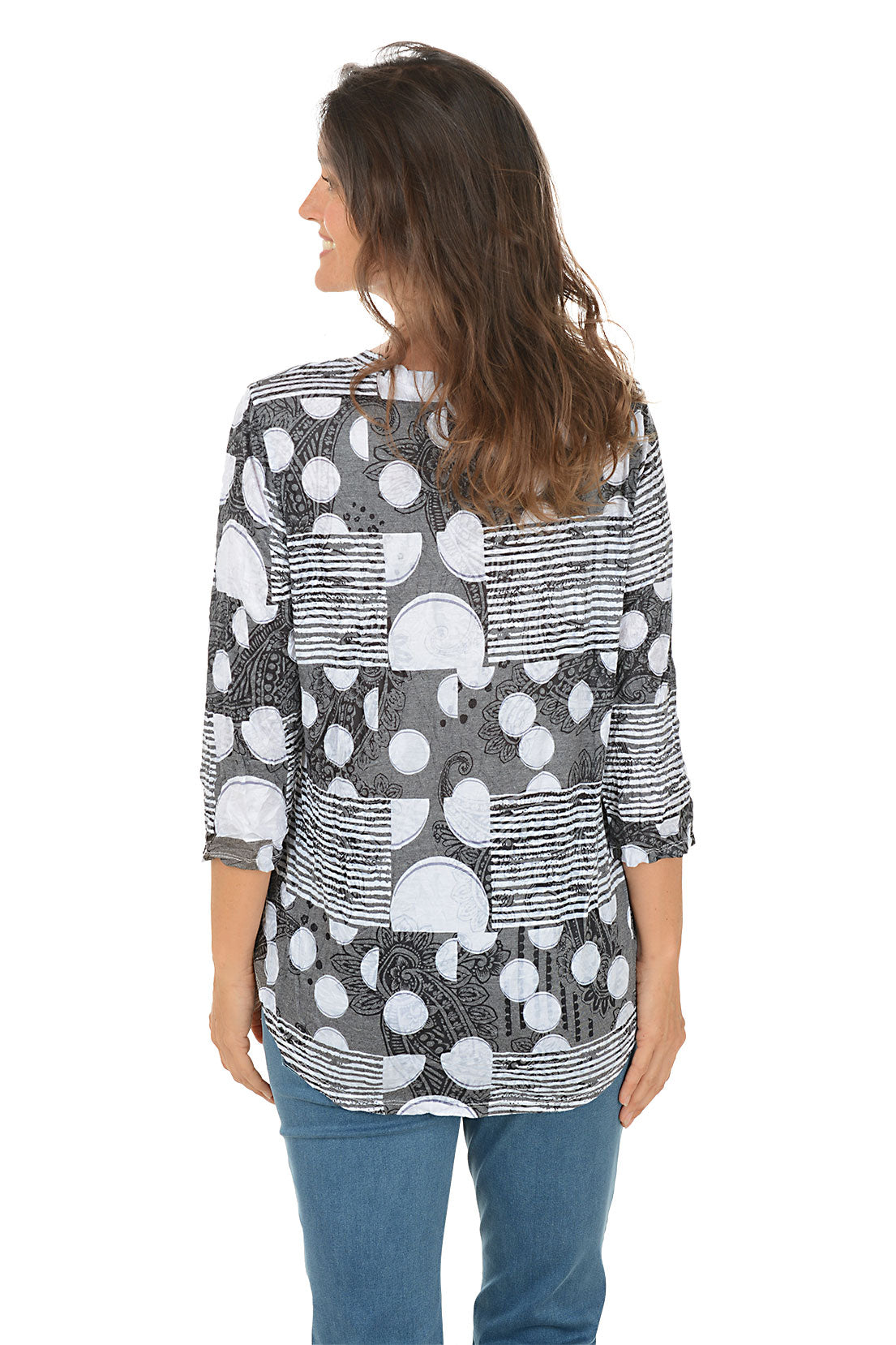 Woman wearing a patterned shirt and jeans on a white background. Back shot.