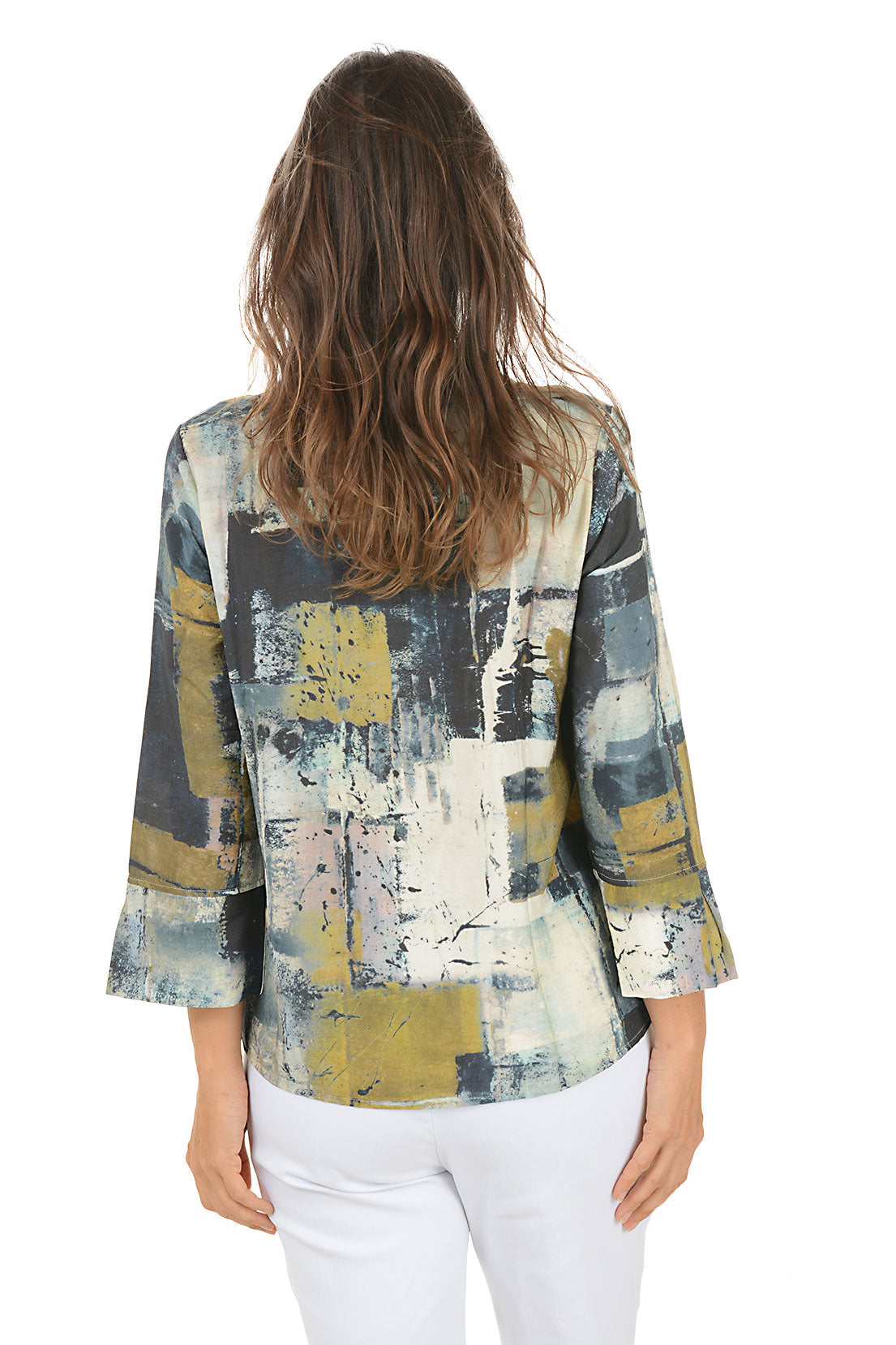 Woman wearing a colorful abstract patterned blouse on a white background. Back shot.