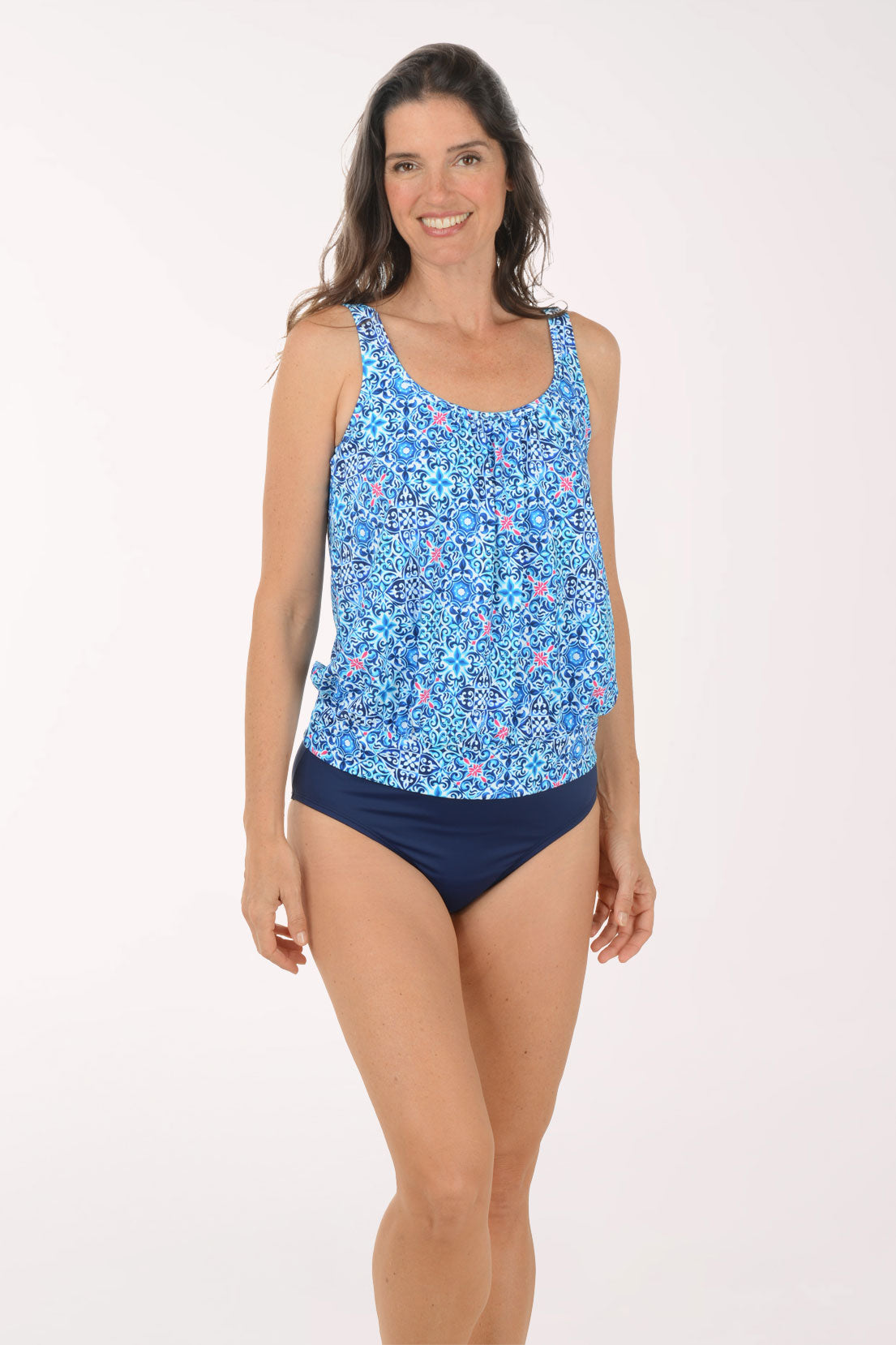 Woman wearing a blue floral tankini top and navy high-waisted bikini bottoms on a white background.