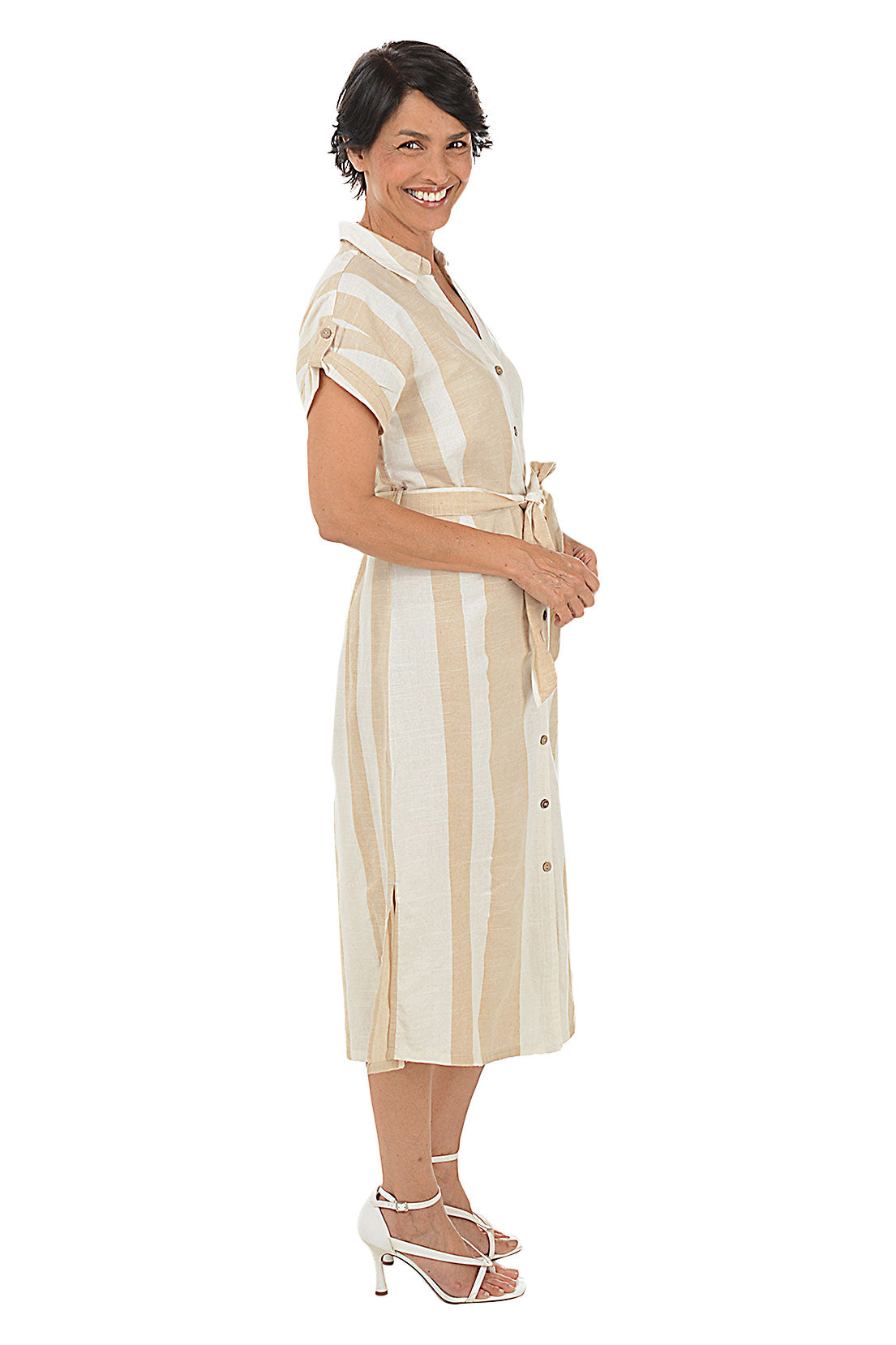 A side shot of a model wearing a beige and white striped button-front midi-length dress with a foldover collar and short dolman sleeves.