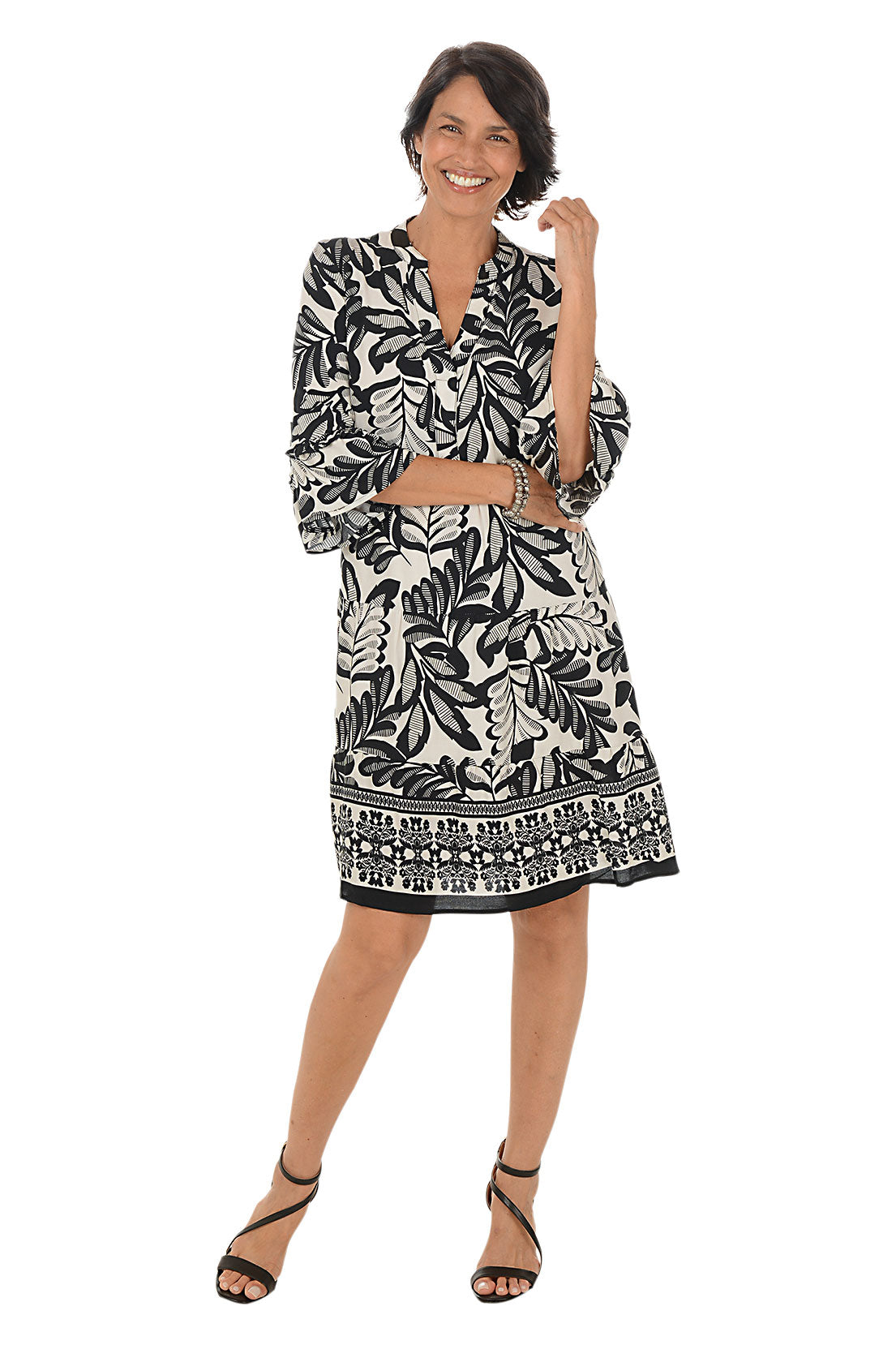 Woman wearing a black and white patterned dress on a white background.