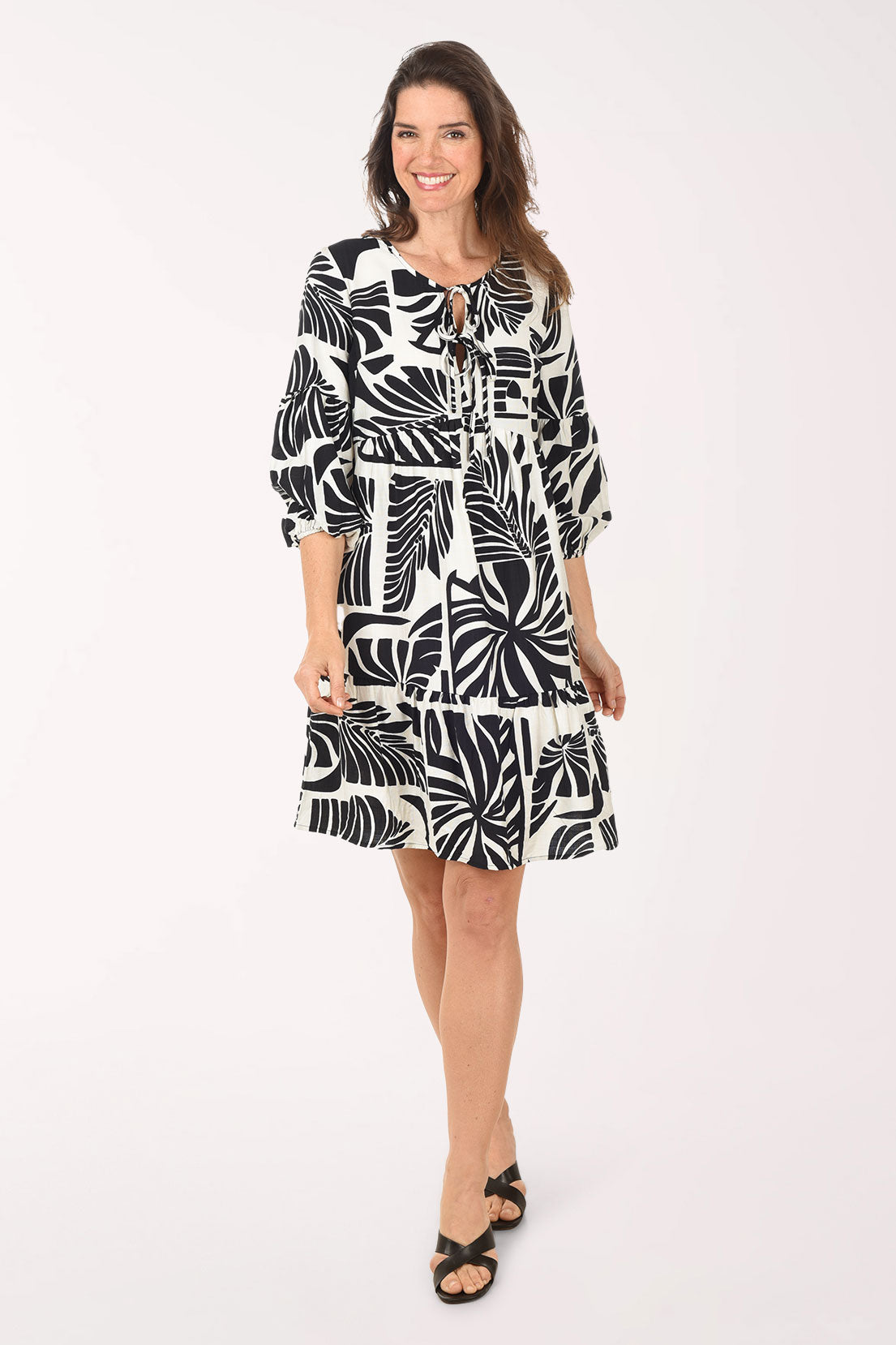 Woman wearing a black and white patterned dress on a white background