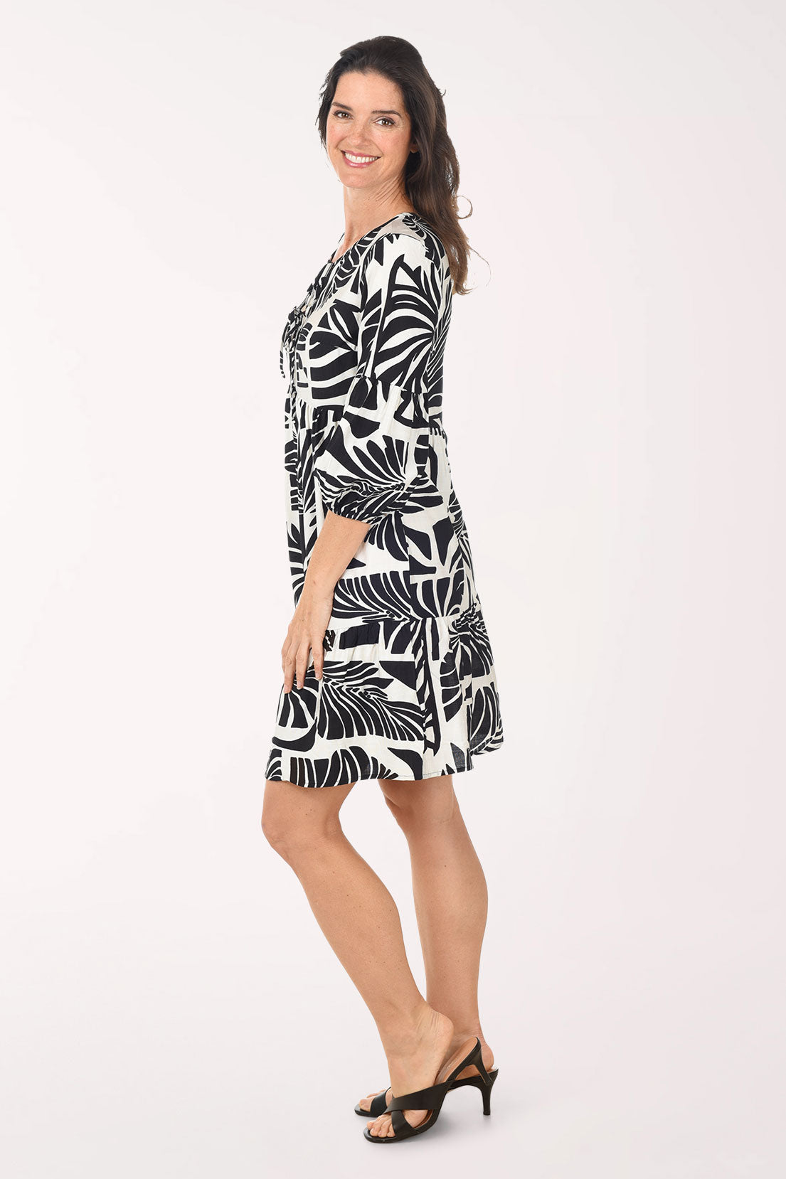 Woman wearing a black and white patterned dress on a white background