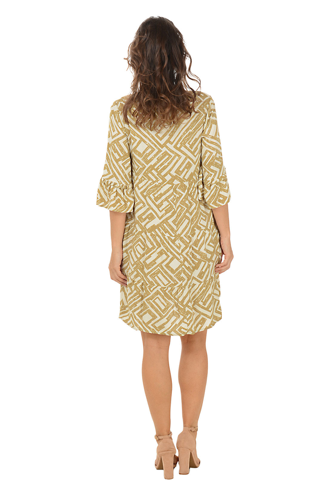 Woman wearing a gold and white patterned dress on a white background. Back shot.