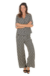 Woman wearing a geometric black and white patterned lounge set on a white background.