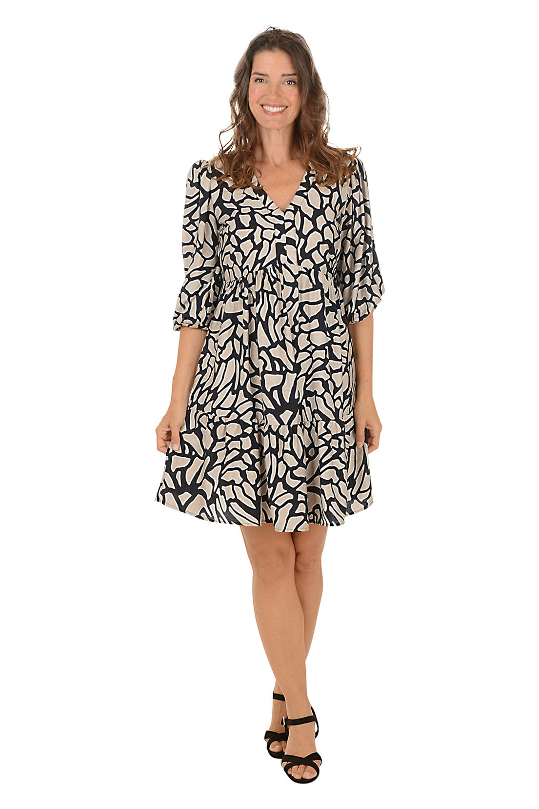 Woman wearing a black and khaki 3/4 sleeve crackle patterned dress on a white background.
