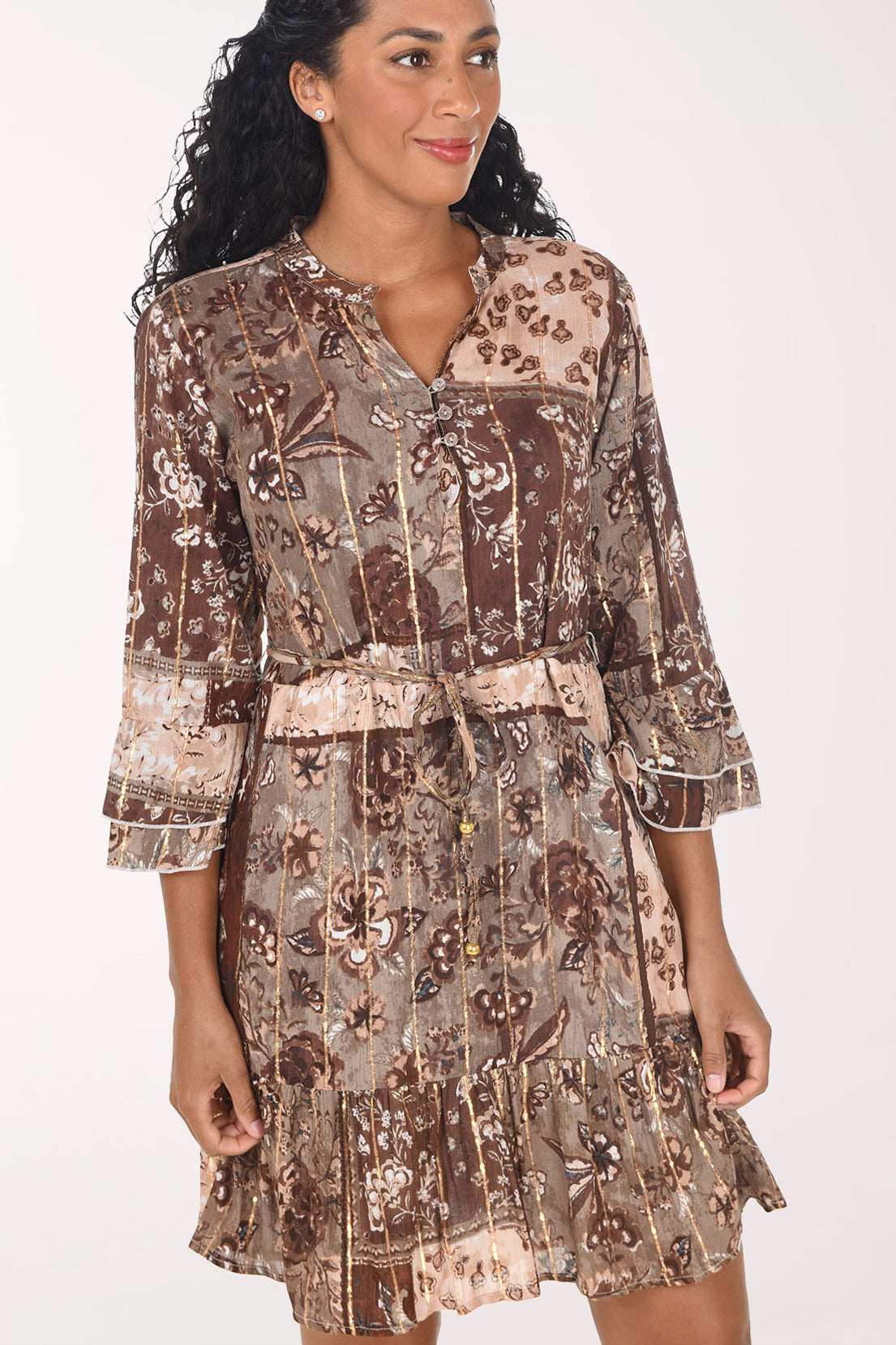 A woman modeling a brown and beige patterned mini dress with three-quarter bell sleeves and a tie waist, posed against a solid white studio background.
