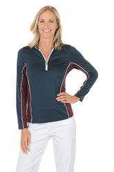 A woman wearing a navy long sleeve activewear top with a maroon color detail under the arm.