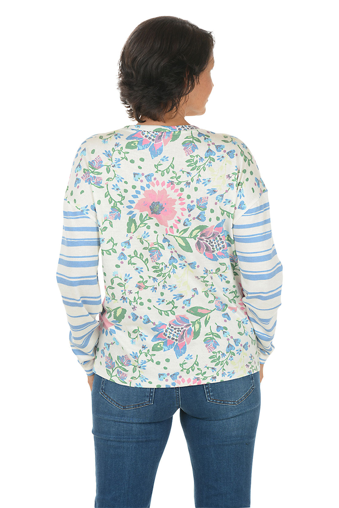 Woman wearing a floral long-sleeve shirt with blue jeans on a white background. Back shot.