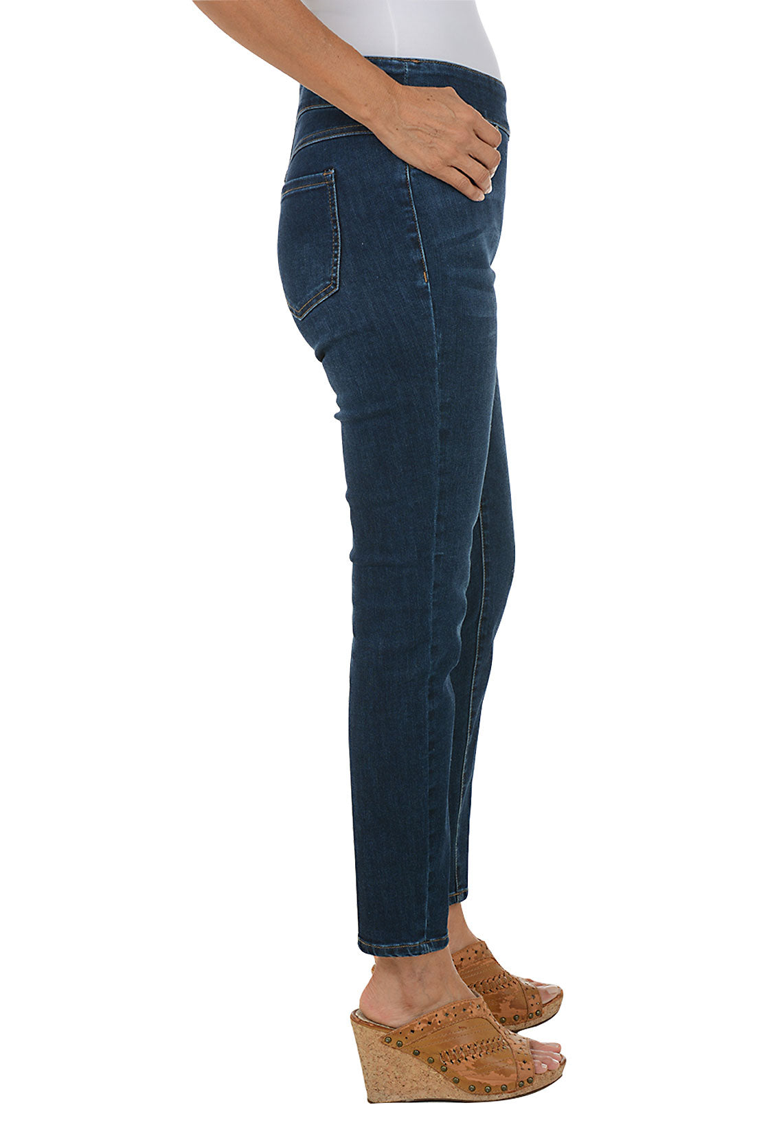 Person wearing dark blue jeans on a white background. Side shot.