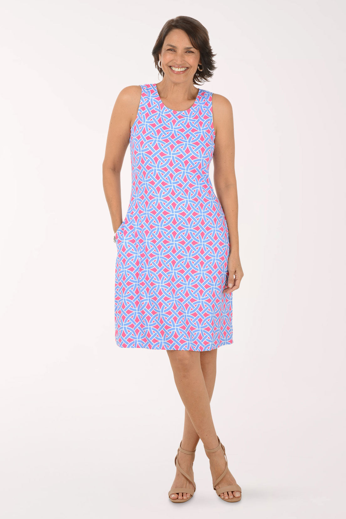 Woman wearing a sleeveless dress with a pattern on a white background