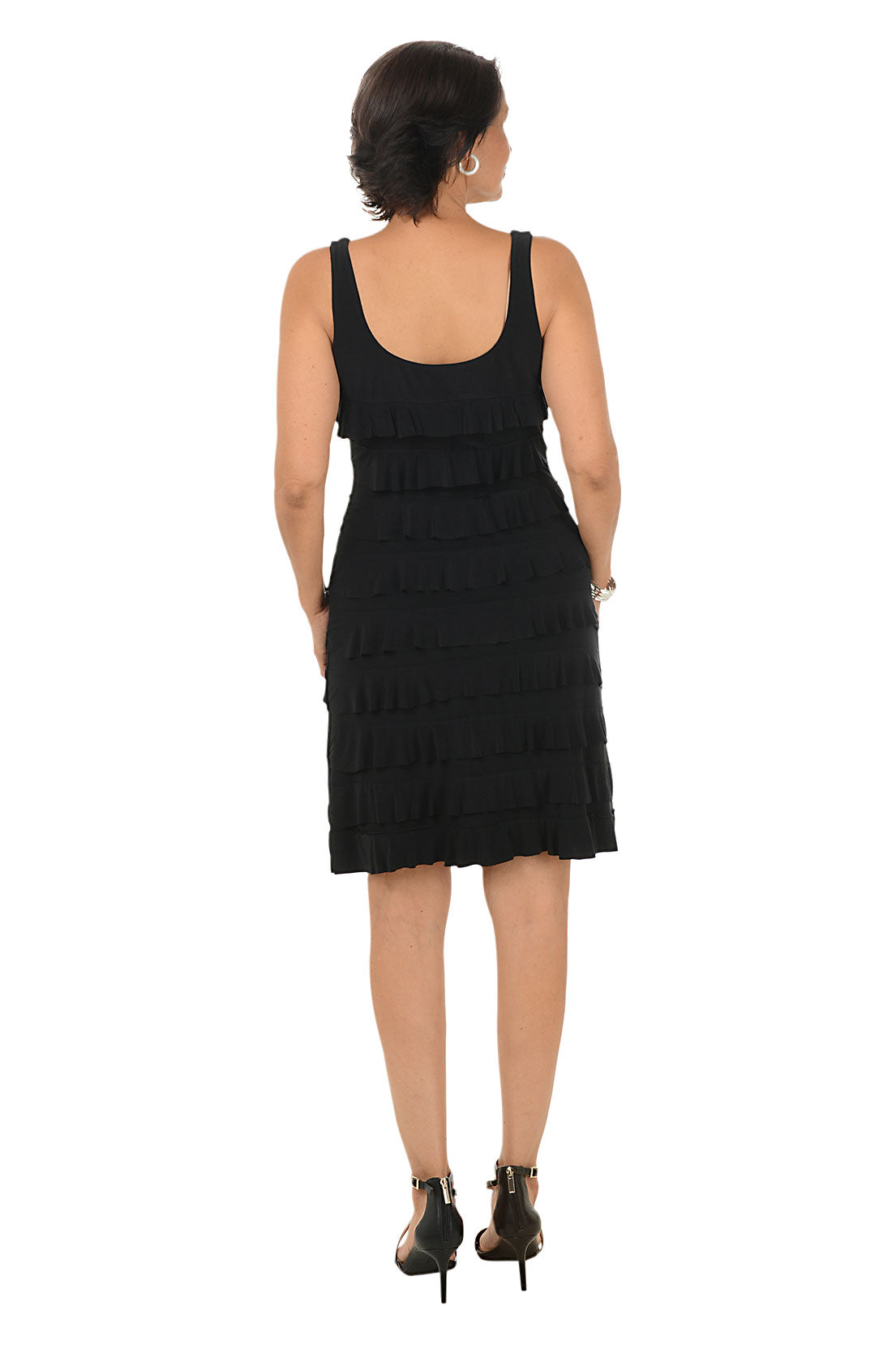 Woman wearing a sleeveless black dress on a white background. Back shot.