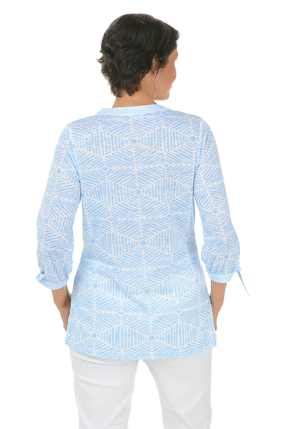 Woman wearing a light blue patterned shirt on a white background. Back shot.