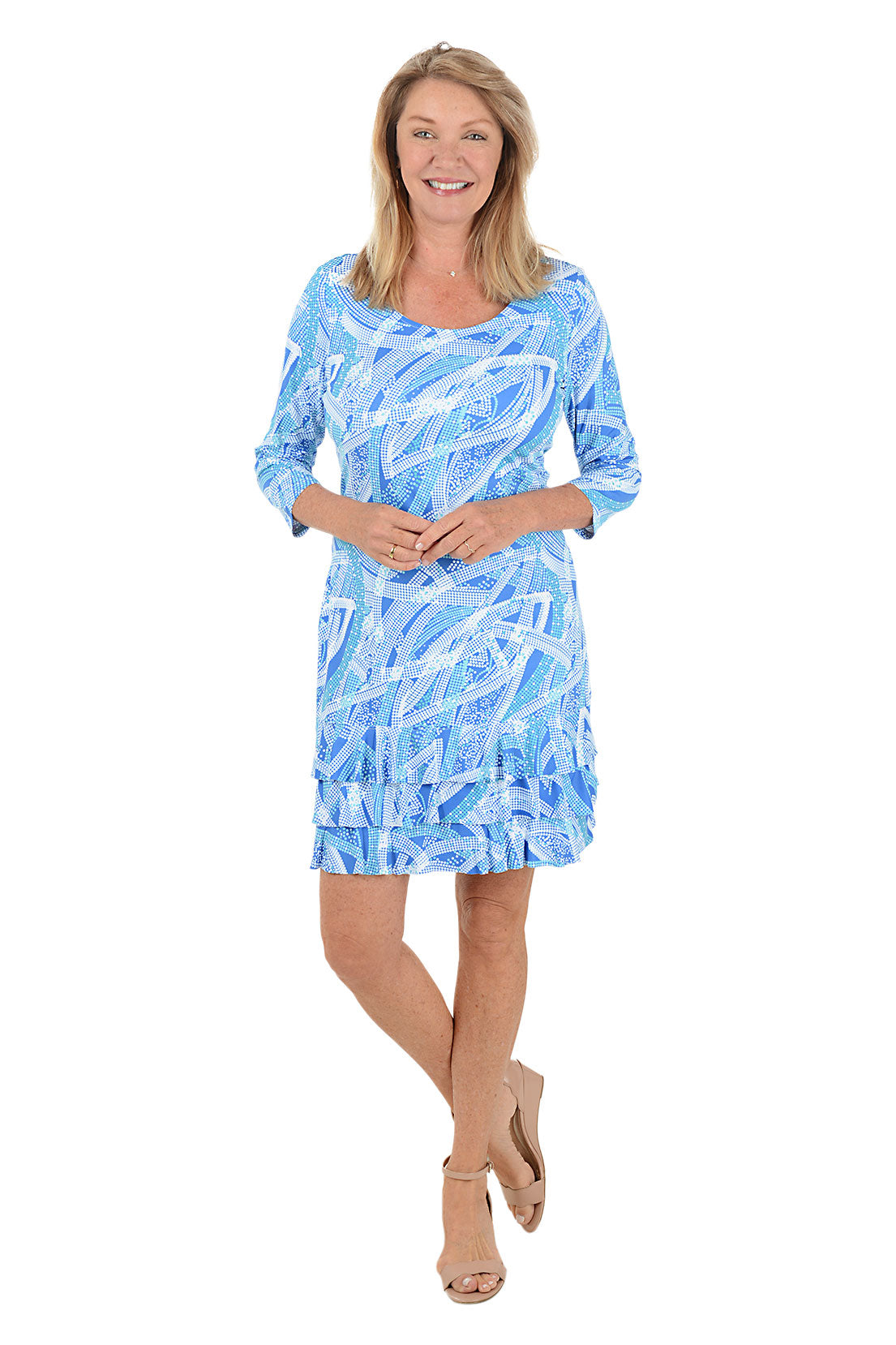 Woman wearing a blue patterned dress with a ruffled tiered hem on a white background.