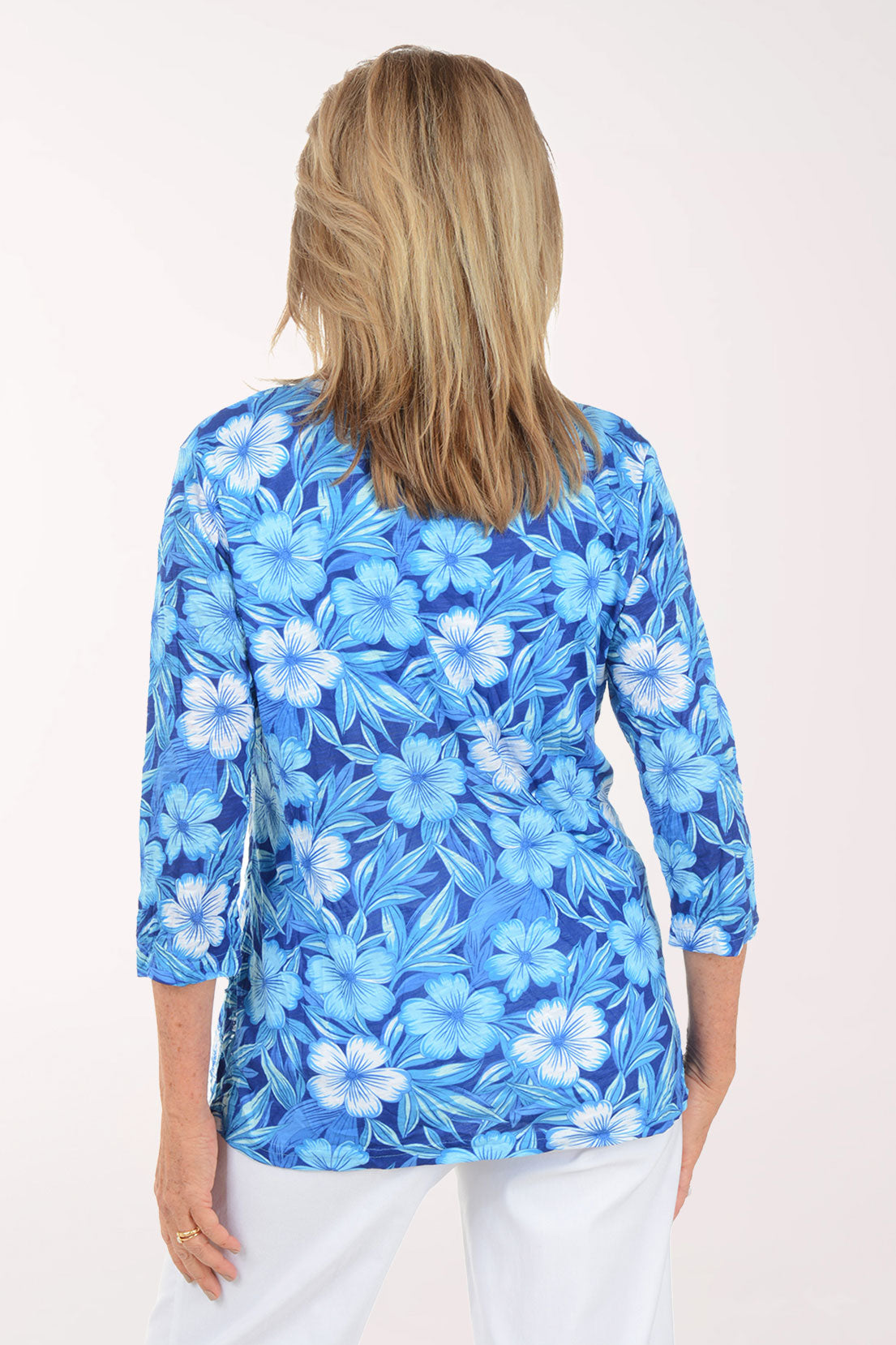 Woman wearing a blue floral print top on a white background