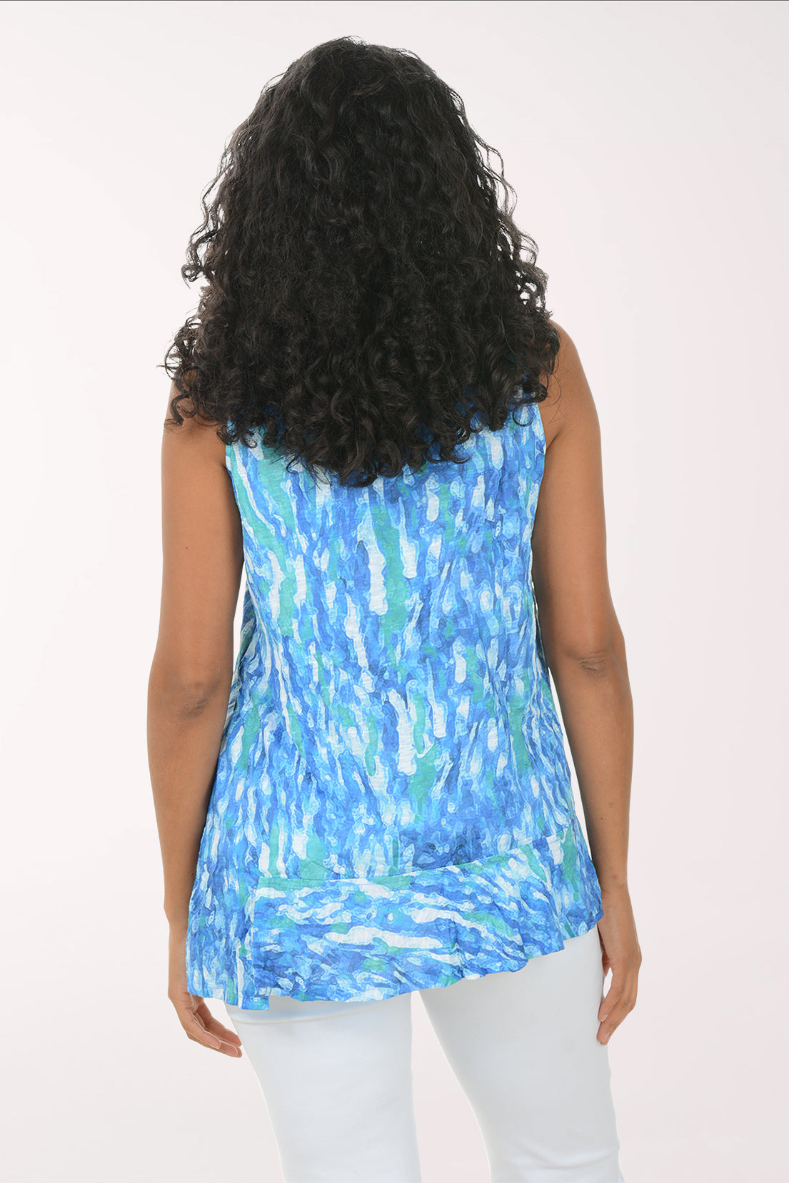 Woman wearing a blue patterned sleeveless top against a white background