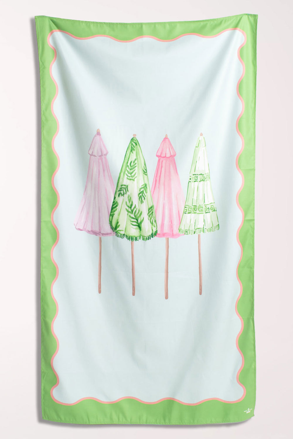 White microfiber beach towel with a wavy green and pink scalloped border and four closed beach umbrellas in pink and green palm-leaf prints across the center.