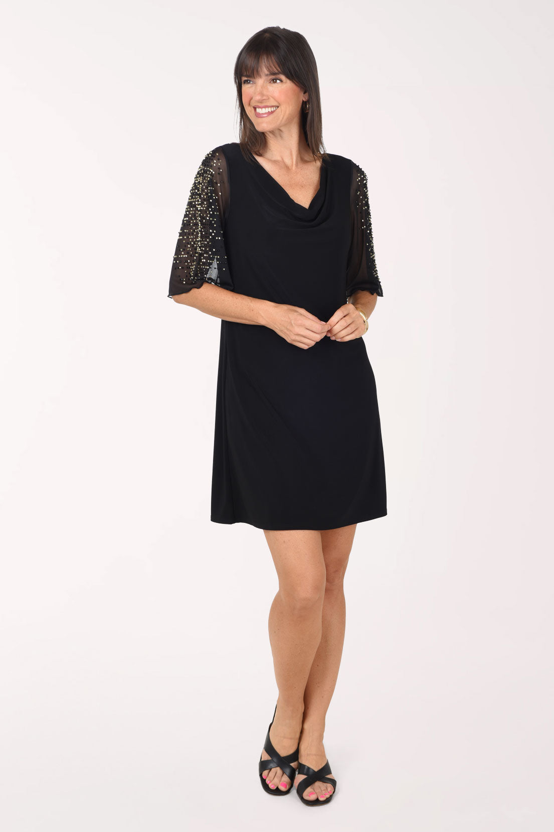 Front view of the black Jeweled Slit Sleeve Cowl Neck Dress showing the relaxed straight shape and the sparkling sheer sleeves, worn with black sandals