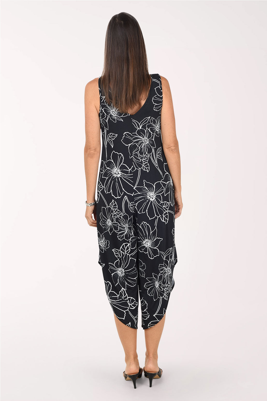 Back view of the Black Floral jumpsuit showing the scooped back neckline, sleeveless armholes and the wide legs with angled hems