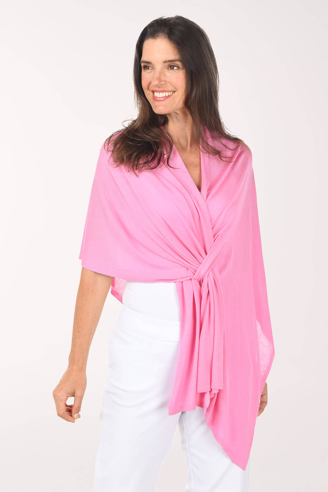 Woman wearing a pink shawl over a white outfit on a white background