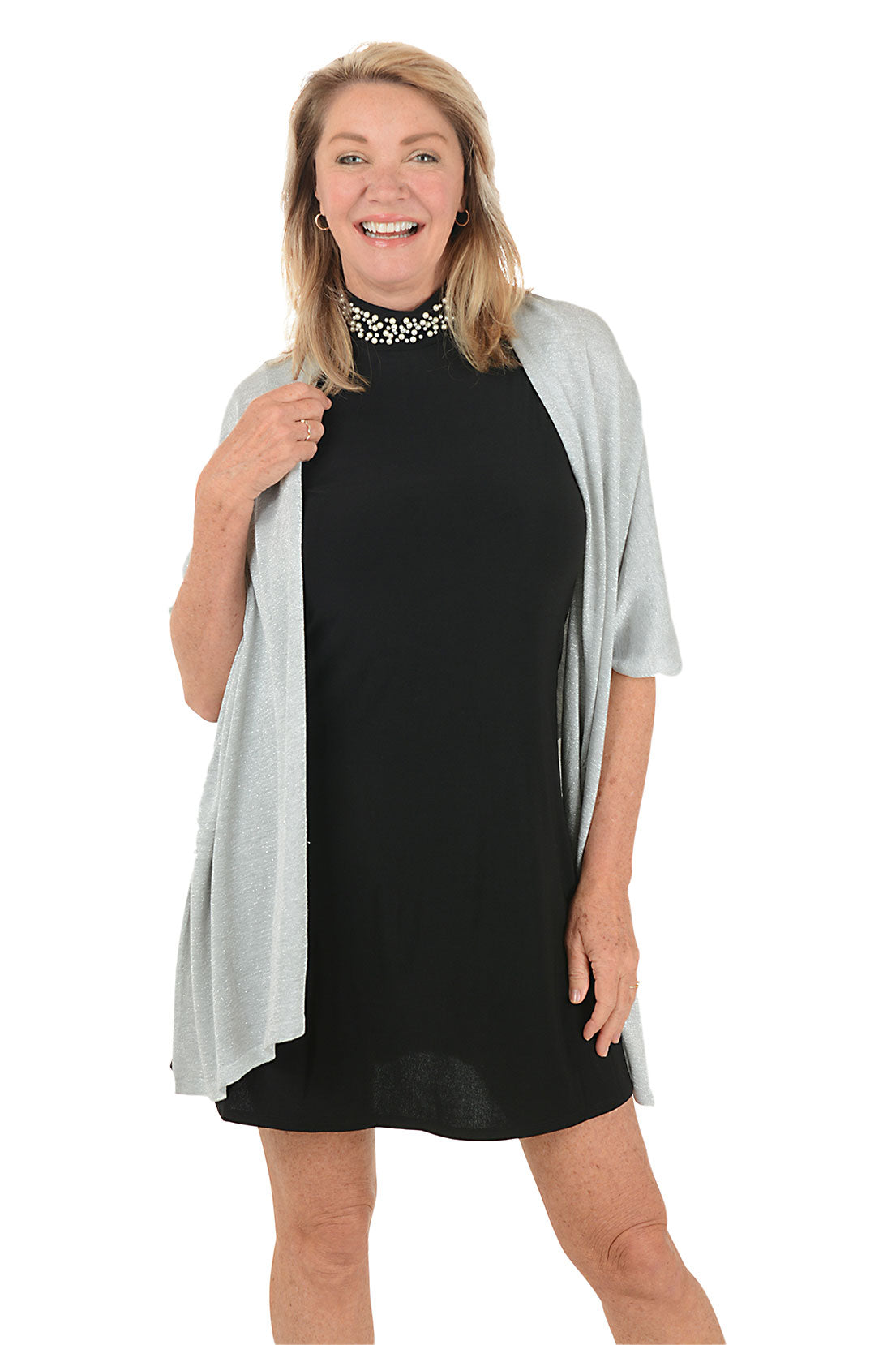 Woman wearing a black dress with a light gray cardigan on a white background.