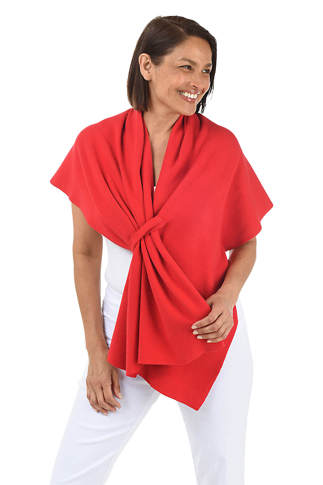 A woman wears a red wrapped shawl over a white top and pants against a white background.