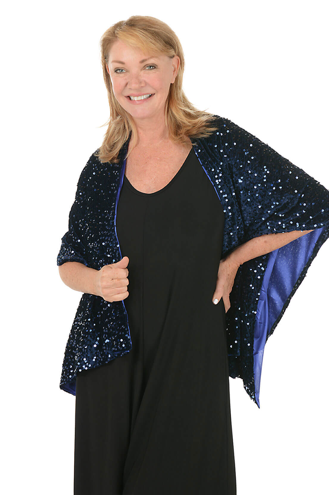 Woman wearing a black dress with a blue sequin shawl on a white background.