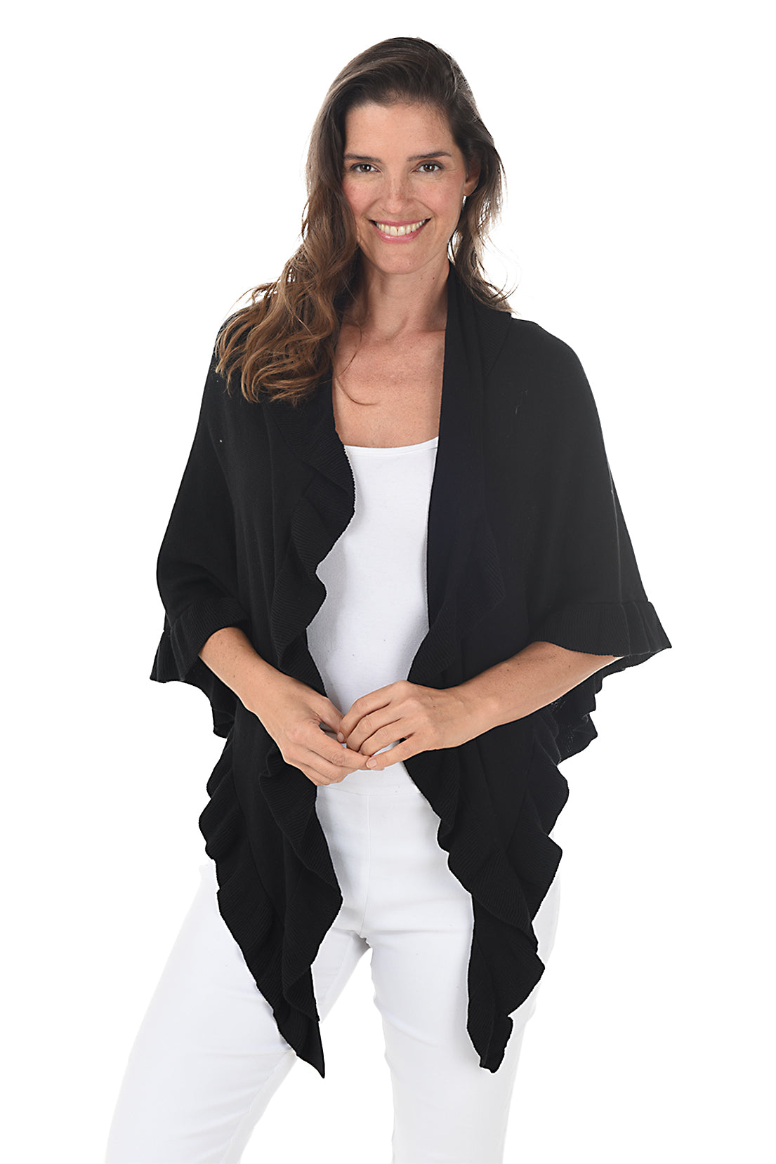 A woman wearing a black open front wrap sweater with ruffled rib-knit trim over a white top and white pants. Second front shot.