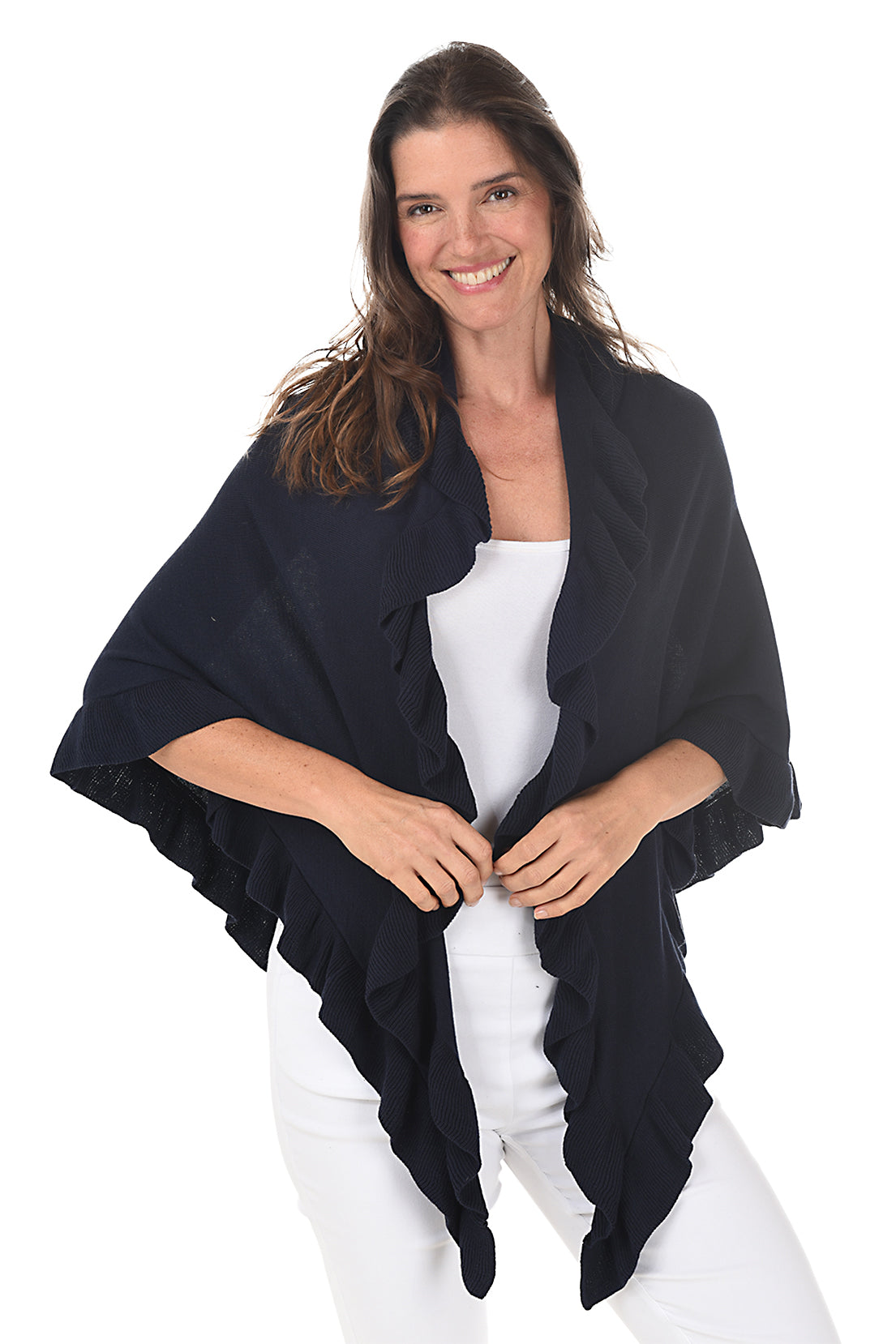 A woman wearing a navy open front wrap sweater with ruffled rib-knit trim over a white top and white pants.