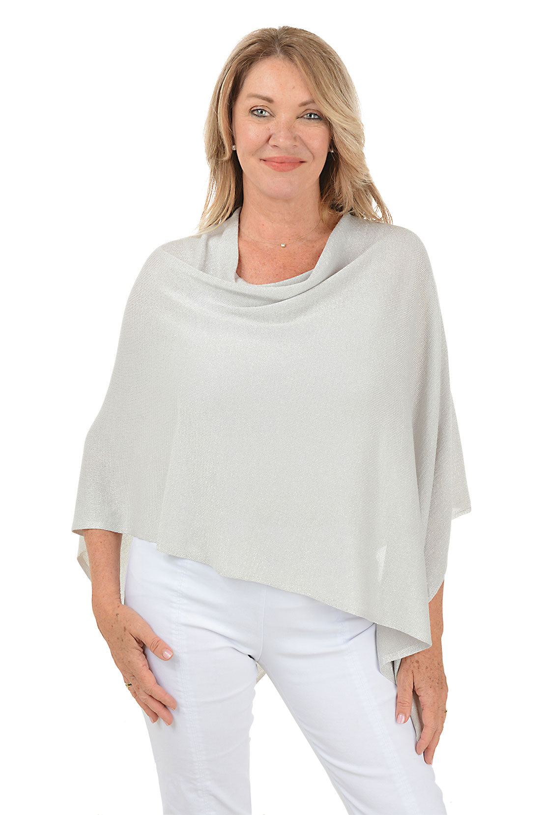 Woman wearing a light gray poncho over a white outfit on a white background.