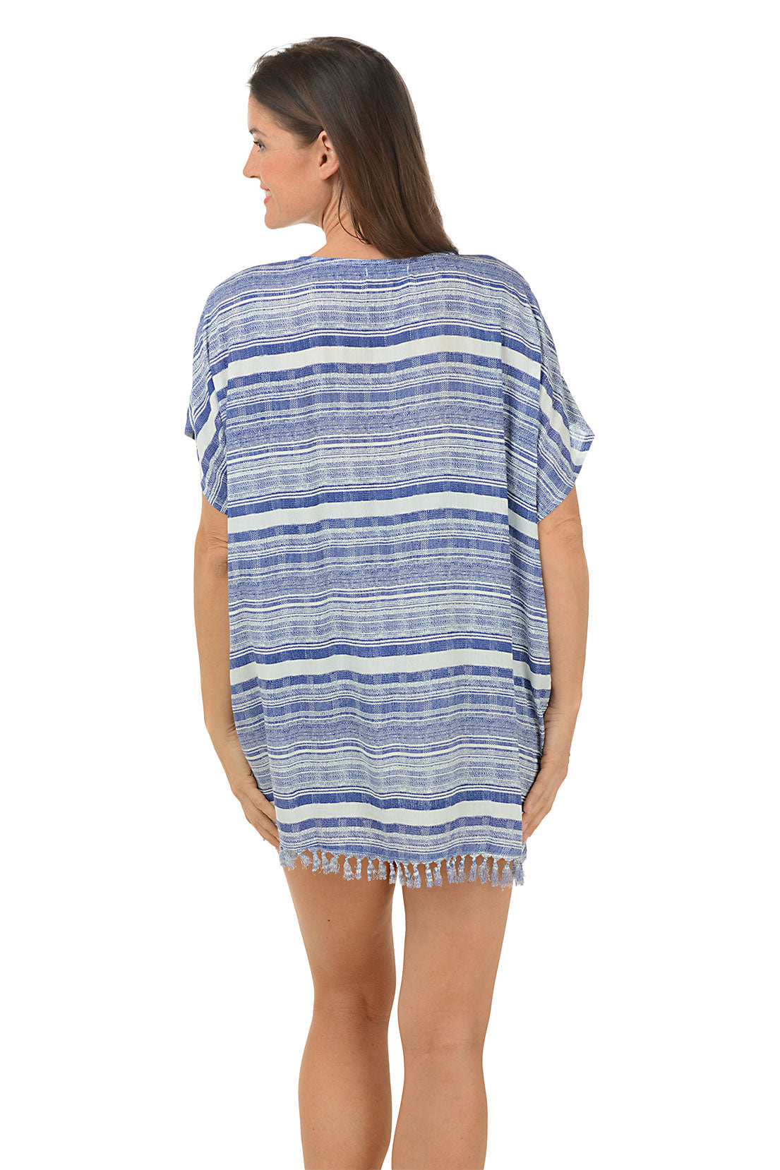 A woman wearing a blue and white striped fringe cover-up with a V-neck and short, loose dolman sleeves. Back shot.