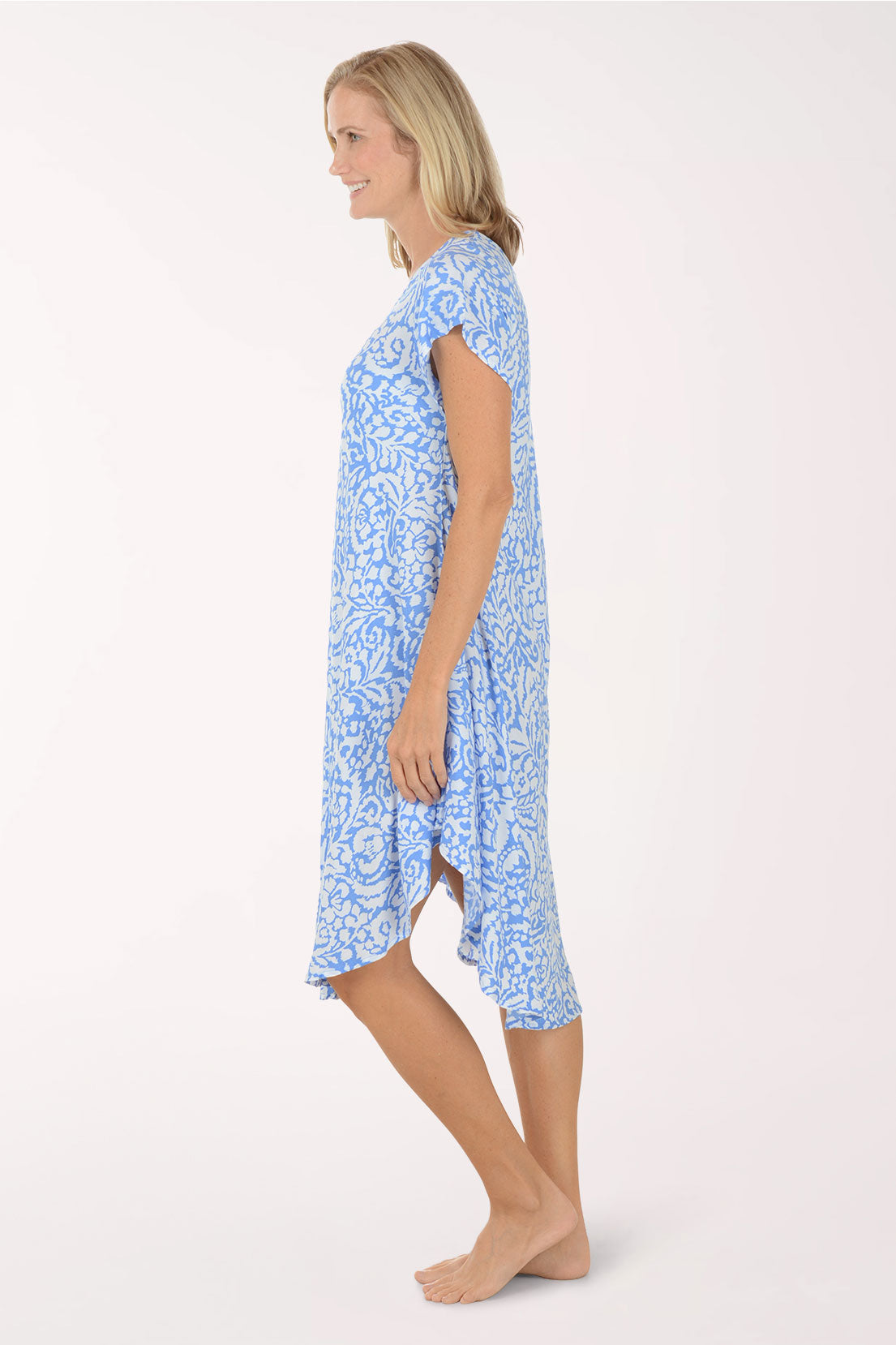 Woman wearing a blue patterned dress on a white background