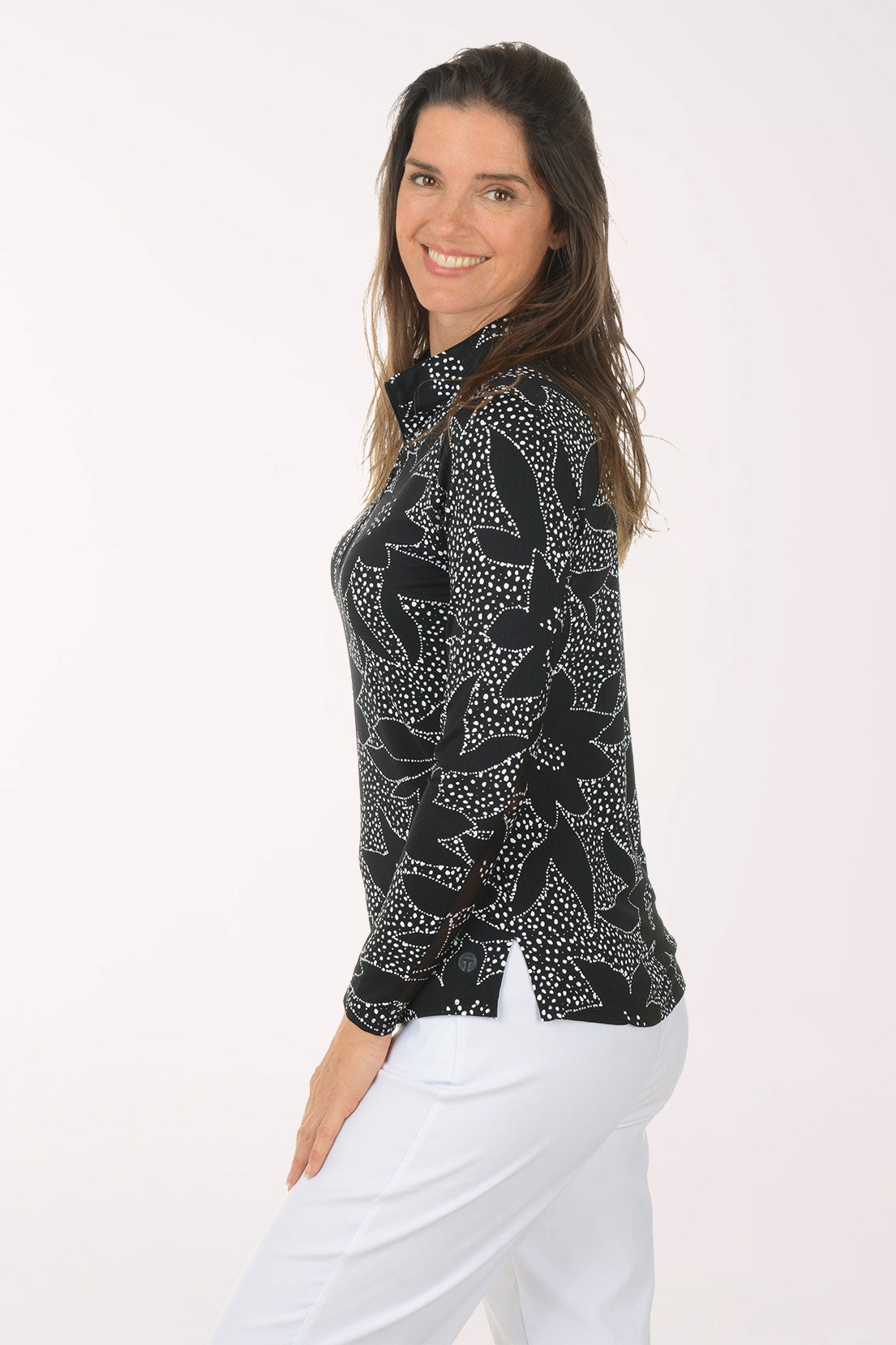 Woman wearing a black floral patterned shirt on a white background