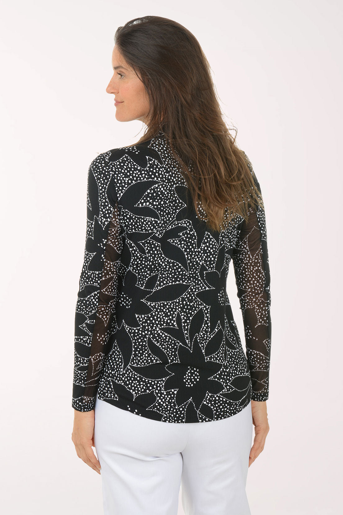 Woman wearing a black floral patterned shirt on a white background