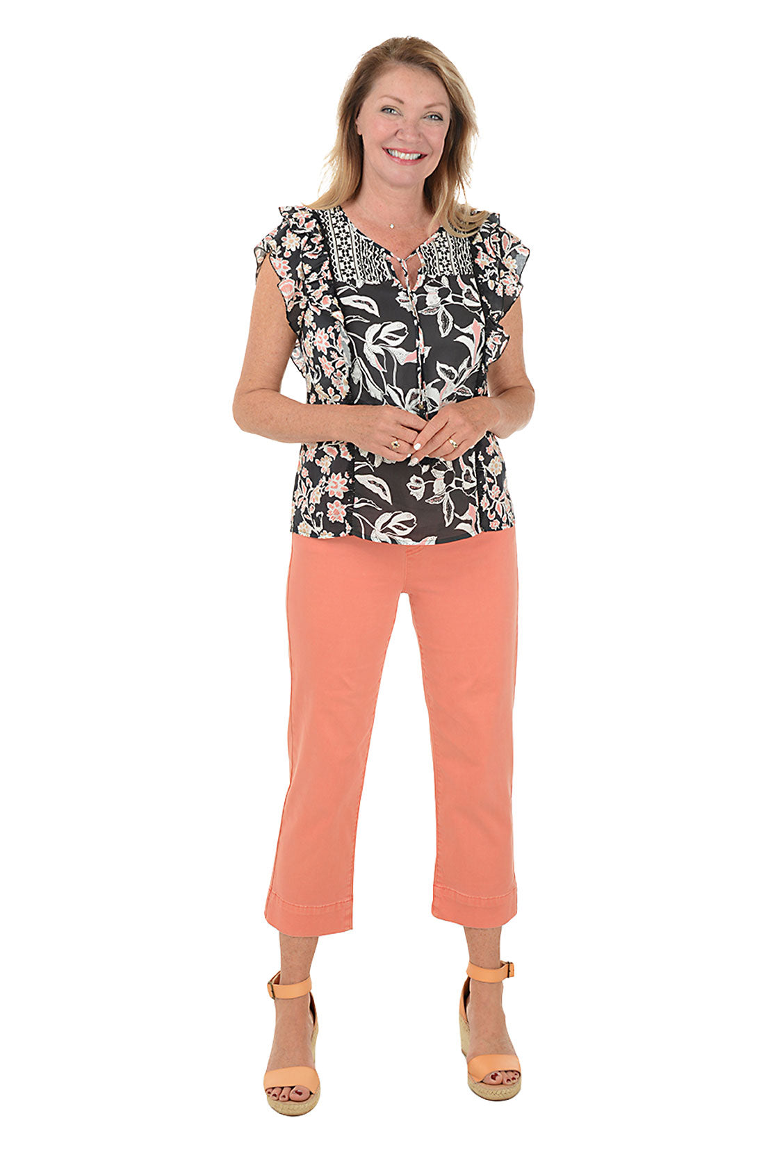 A full length shot of a model wearing a pair of orange denim kick flare crop pants with a mid-rise waist and belt loops.