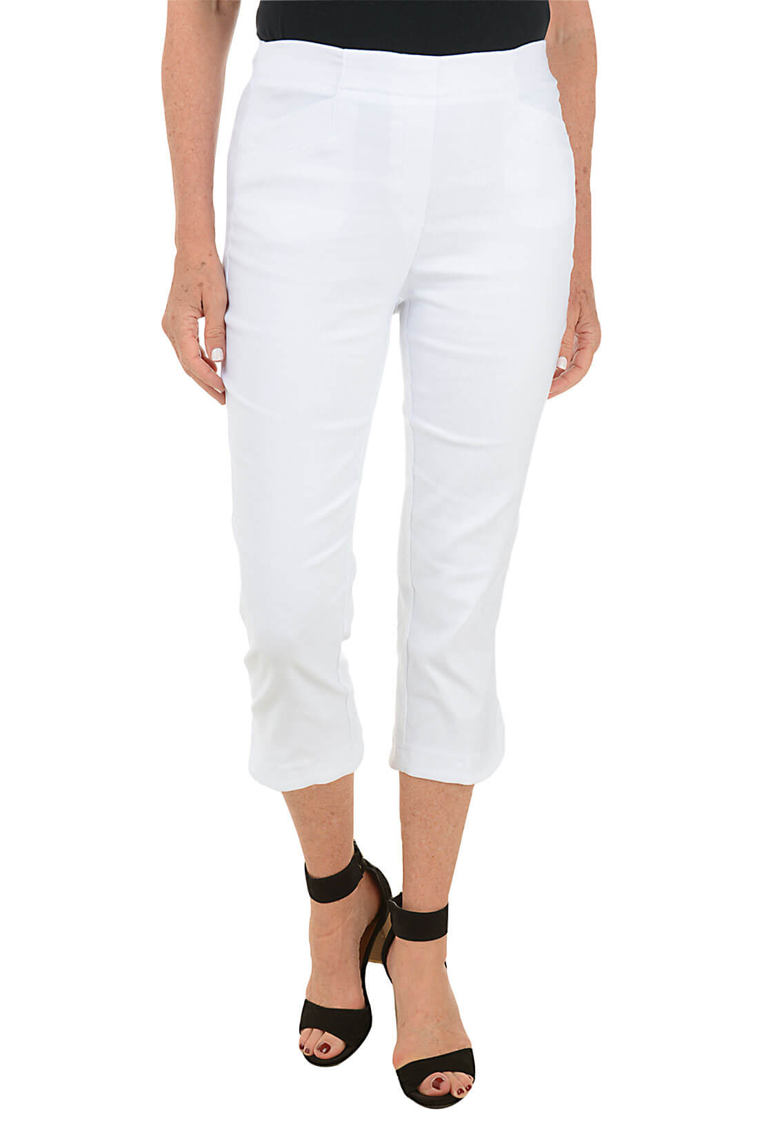 A front shot of a model wearing a pair of white capri pants with a stretch waistband and tummy control lining, featuring dual front pockets and a tulip hemline.
