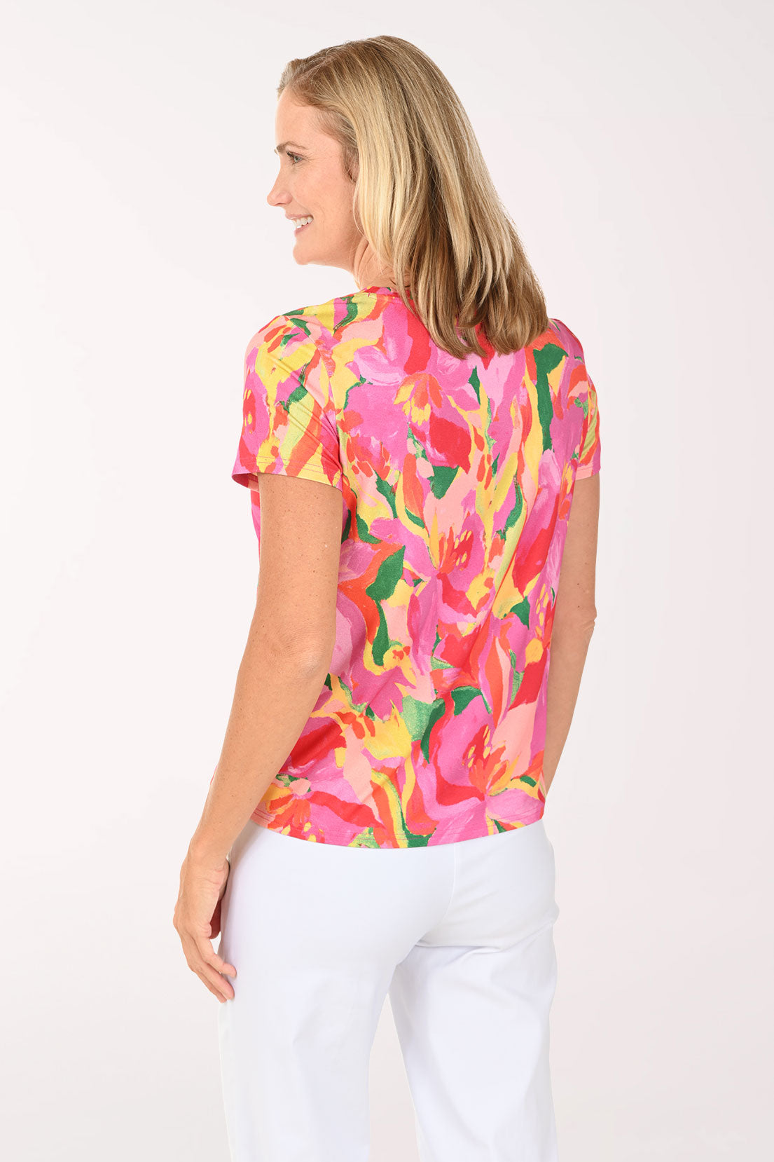 Woman wearing a colorful floral top on a white background