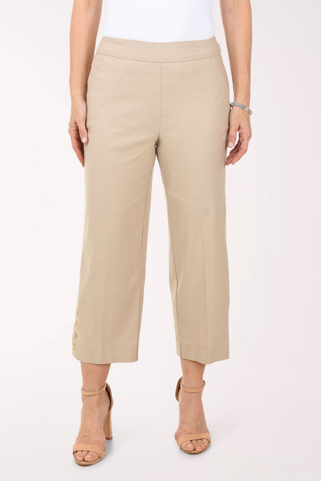 Beige pants worn by a person on a white background