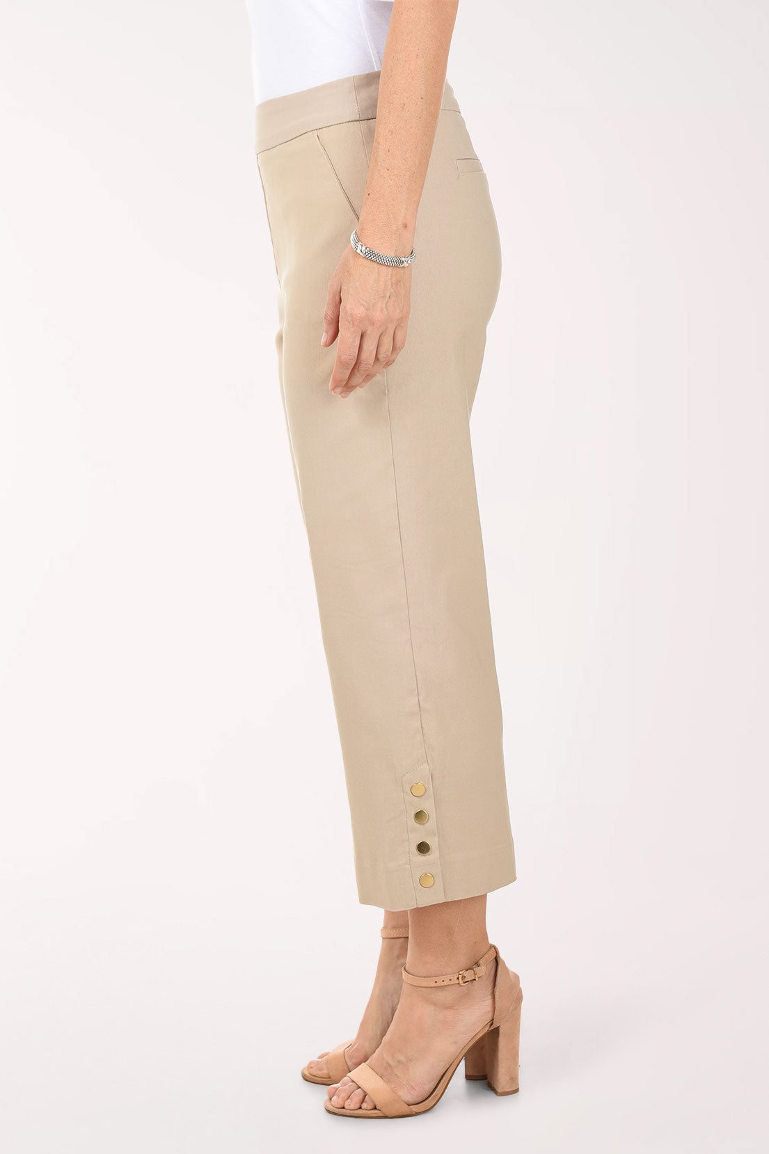 Beige pants worn by a person on a white background