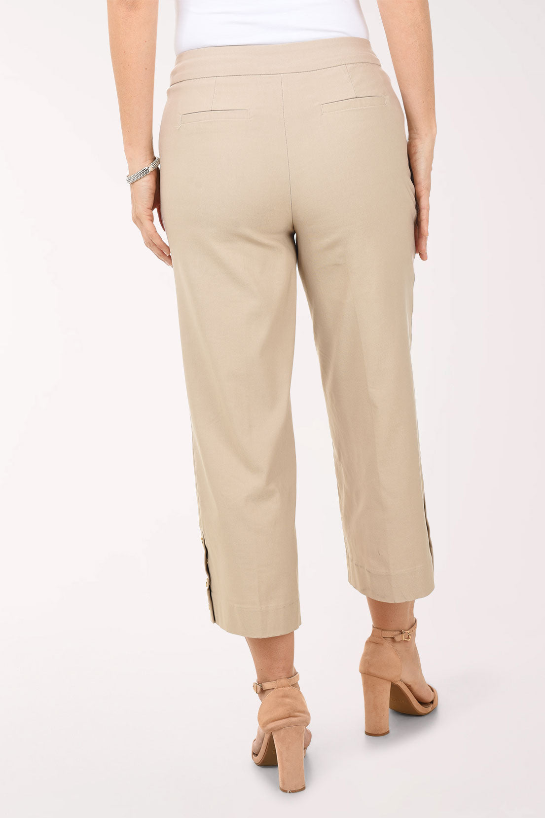 Beige pants worn by a person on a white background